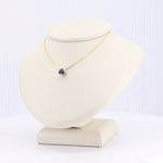 Load image into Gallery viewer, Gold necklace with a blue gemstone pendant on a display bust, perfect for elegant style and everyday wear.