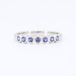 Load image into Gallery viewer, Purple gemstone band ring in sterling silver, featuring alternating round cut stones in a modern, sleek design.