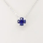 Load image into Gallery viewer, Royal blue sapphire pendant necklace in sterling silver, featuring a round cut stone with intricate halo detailing.