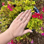 Load image into Gallery viewer, Gold vintage-style ring with a light blue stone, worn with a delicate gold bracelet, against vibrant floral backdrop.