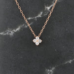 Load image into Gallery viewer, Rose gold flower pendant necklace with four sparkling cubic zirconia stones on a delicate chain.