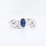Load image into Gallery viewer, Sterling silver ring with an oval blue sapphire and intricate swirl design, perfect for elegant occasions.