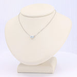 Load image into Gallery viewer, Sterling silver necklace with a rectangular blue topaz pendant on a soft display stand. Elegant and minimalist design.