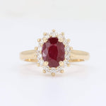 Load image into Gallery viewer, Gold ring featuring an oval ruby centerstone surrounded by a halo of sparkling diamonds. Elegant and timeless design.
