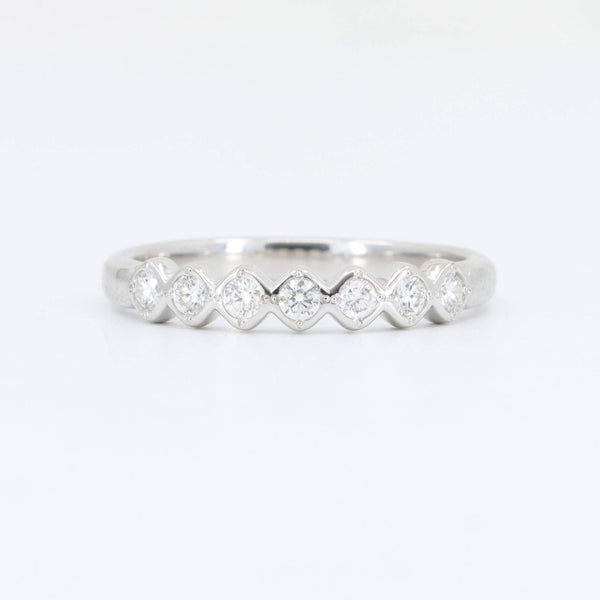 Elegant silver ring with alternating diamond accents in a chevron design, perfect for stacking or as an engagement band.