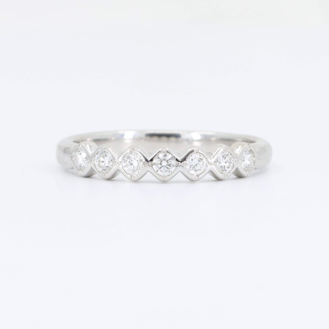 Elegant silver ring with alternating diamond accents in a chevron design, perfect for stacking or as an engagement band.