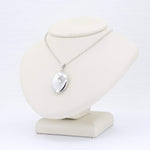Load image into Gallery viewer, Silver oval locket necklace with diamond accent on a delicate chain, displayed elegantly on a neutral-colored bust.