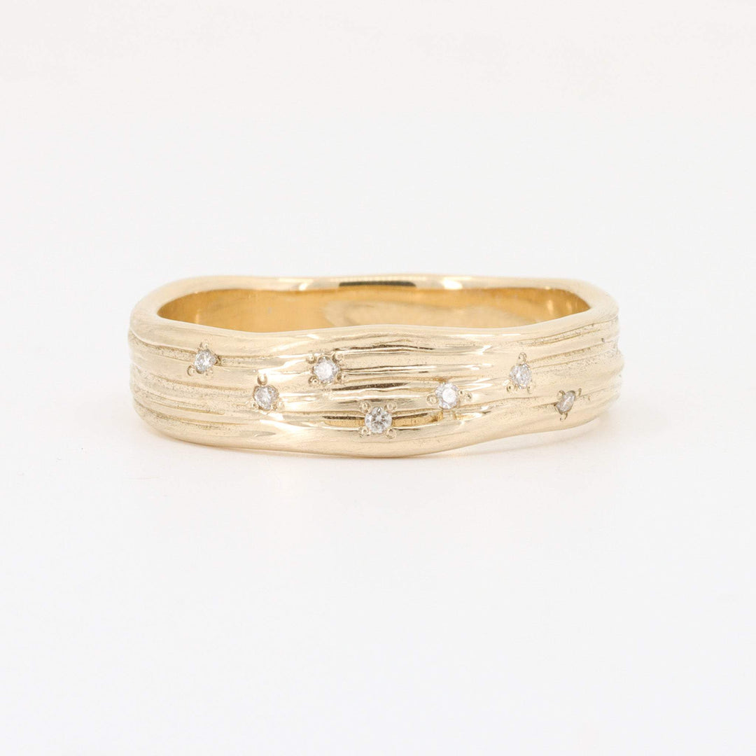 Gold textured ring with scattered diamonds, featuring a modern rustic design. Ideal for elegant occasions.