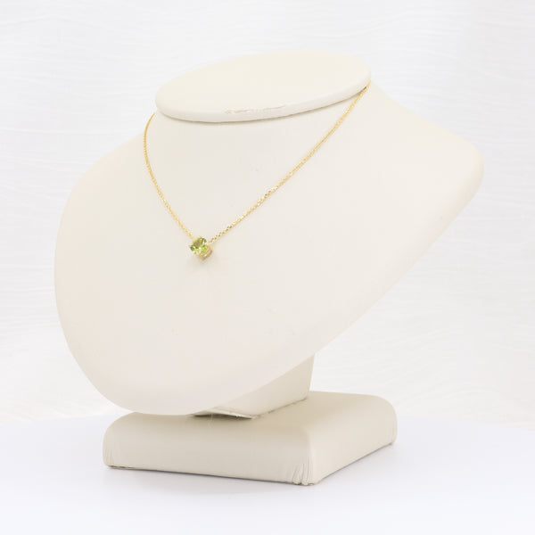 Green peridot solitaire pendant on an 18-inch yellow gold chain.