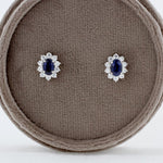 Load image into Gallery viewer, Oval Blue Sapphire and Diamond Halo Stud Earrings in White Gold
