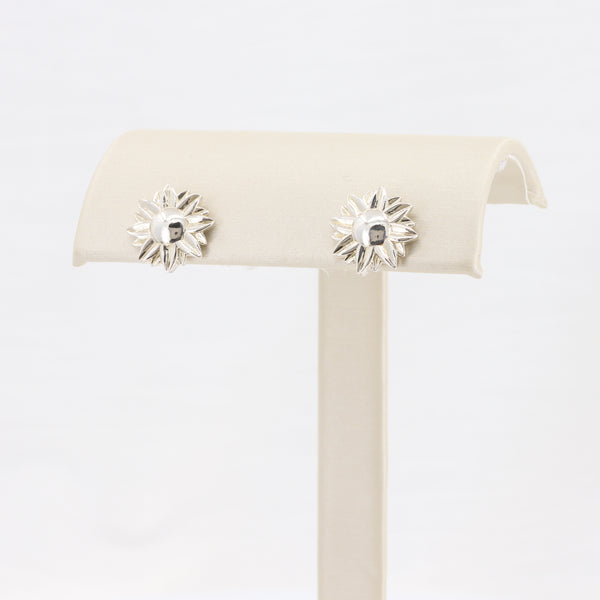 Silver sunburst earrings with a central gemstone, perfect for a trendy, sophisticated look.