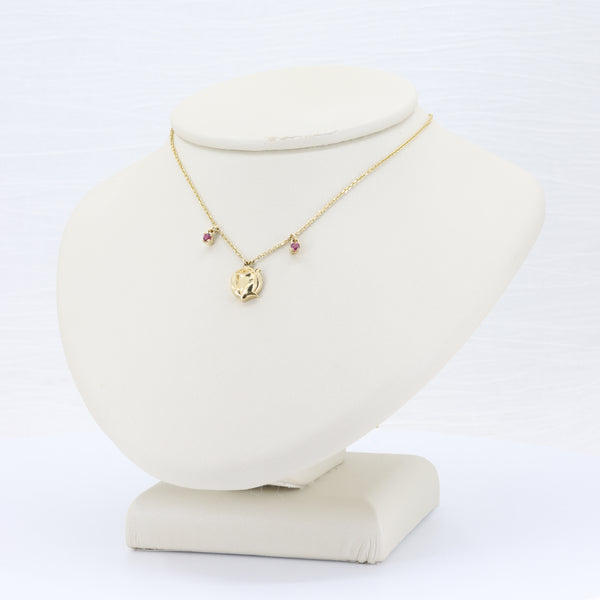 Yellow gold rose pendant necklace with garnet accents on an 18-inch chain