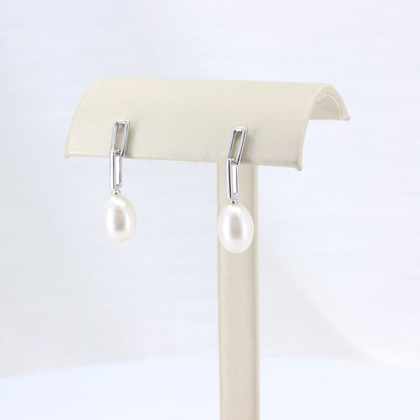 Elegant silver earrings featuring a sleek design and lustrous white pearl drops, perfect for any occasion.