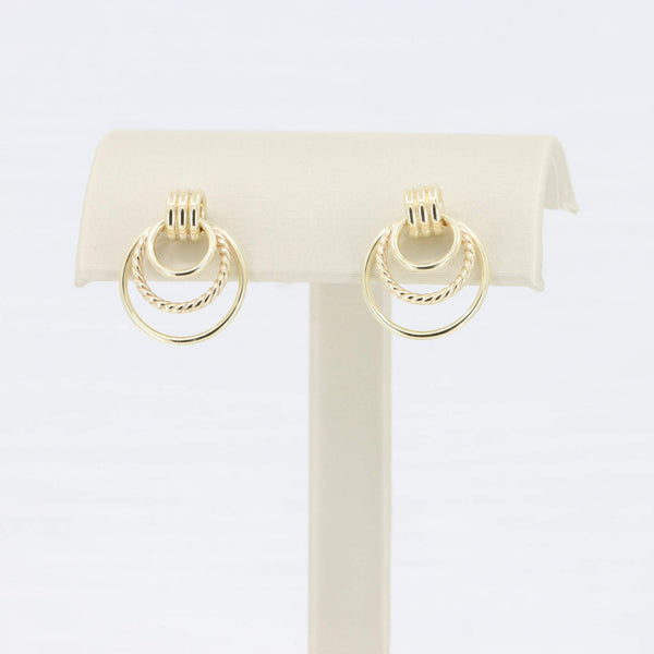 Gold double hoop earrings with twisted detail, perfect for elegant or casual outfits.