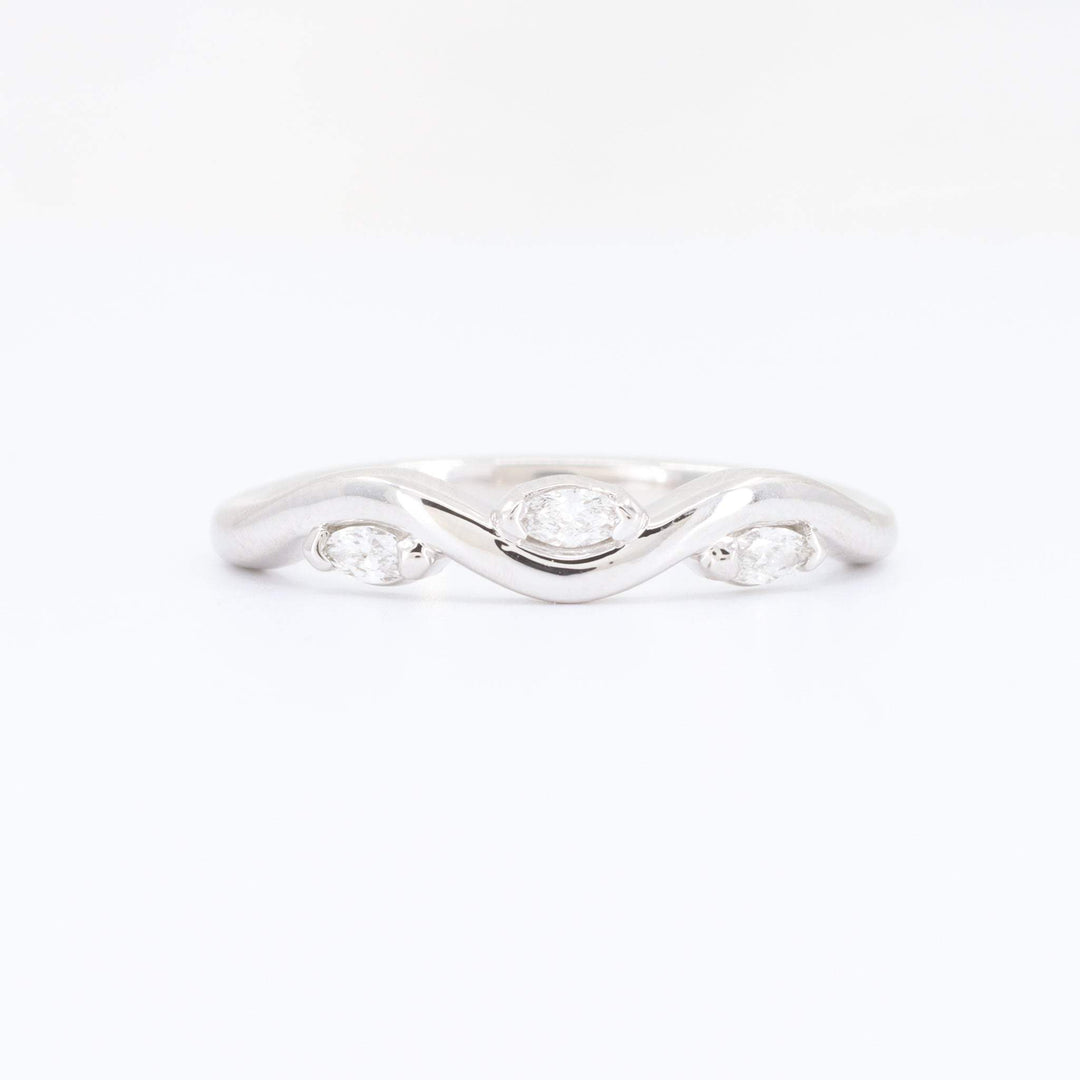 White gold wave ring with three marquise-cut diamonds, elegant and modern design. Perfect for engagement or anniversary.