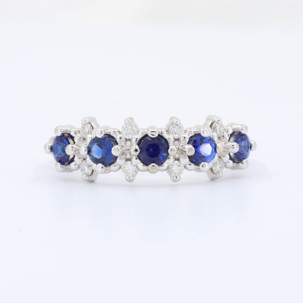 Elegant silver band ring with blue sapphires and shimmering diamonds, perfect for any occasion.