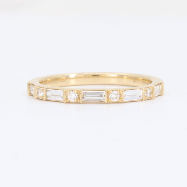 Elegant gold band ring with baguette and round diamonds, perfect for stacking or as a wedding band.